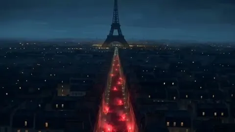 Vue aérienne de Paris la nuit, une avenue remplie de fumigènes rouges mène à la tour Eiffel